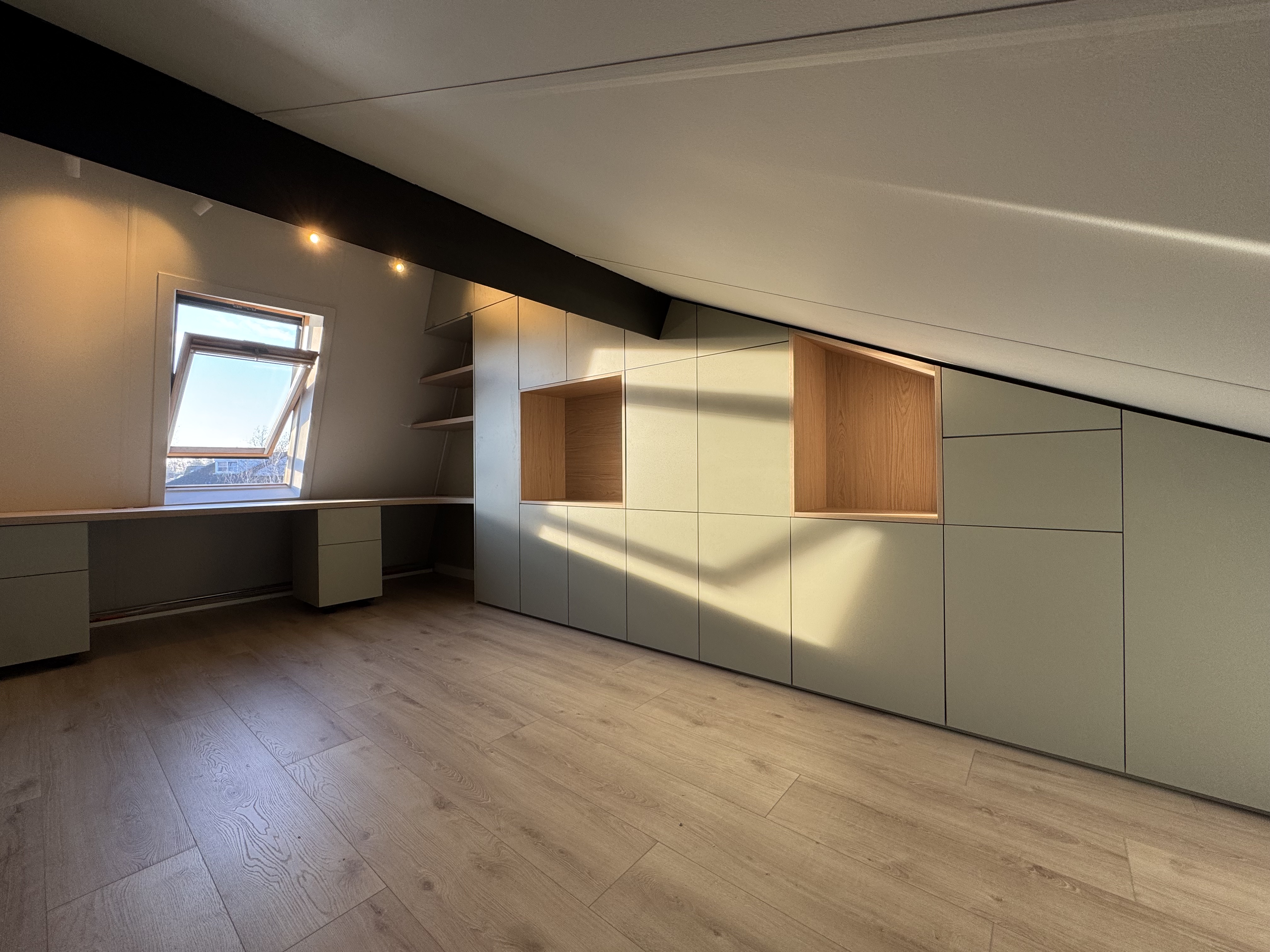 Maatwerk zolderinrichting met sage-groene kasten langs schuine wand en bureau op maat, Assen — Samsam Interieur